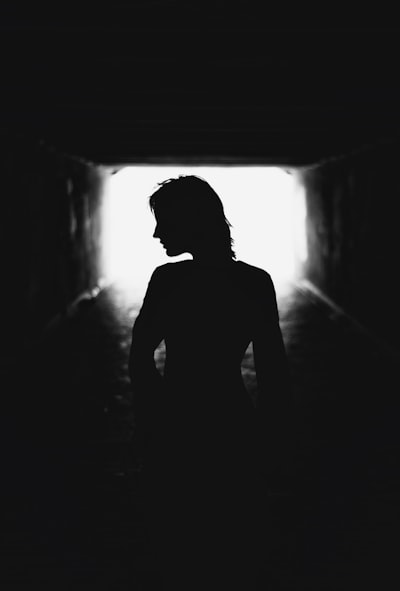 Person's Silhouette In A Dark Tunnel With Light Ahead. wallpaper preview