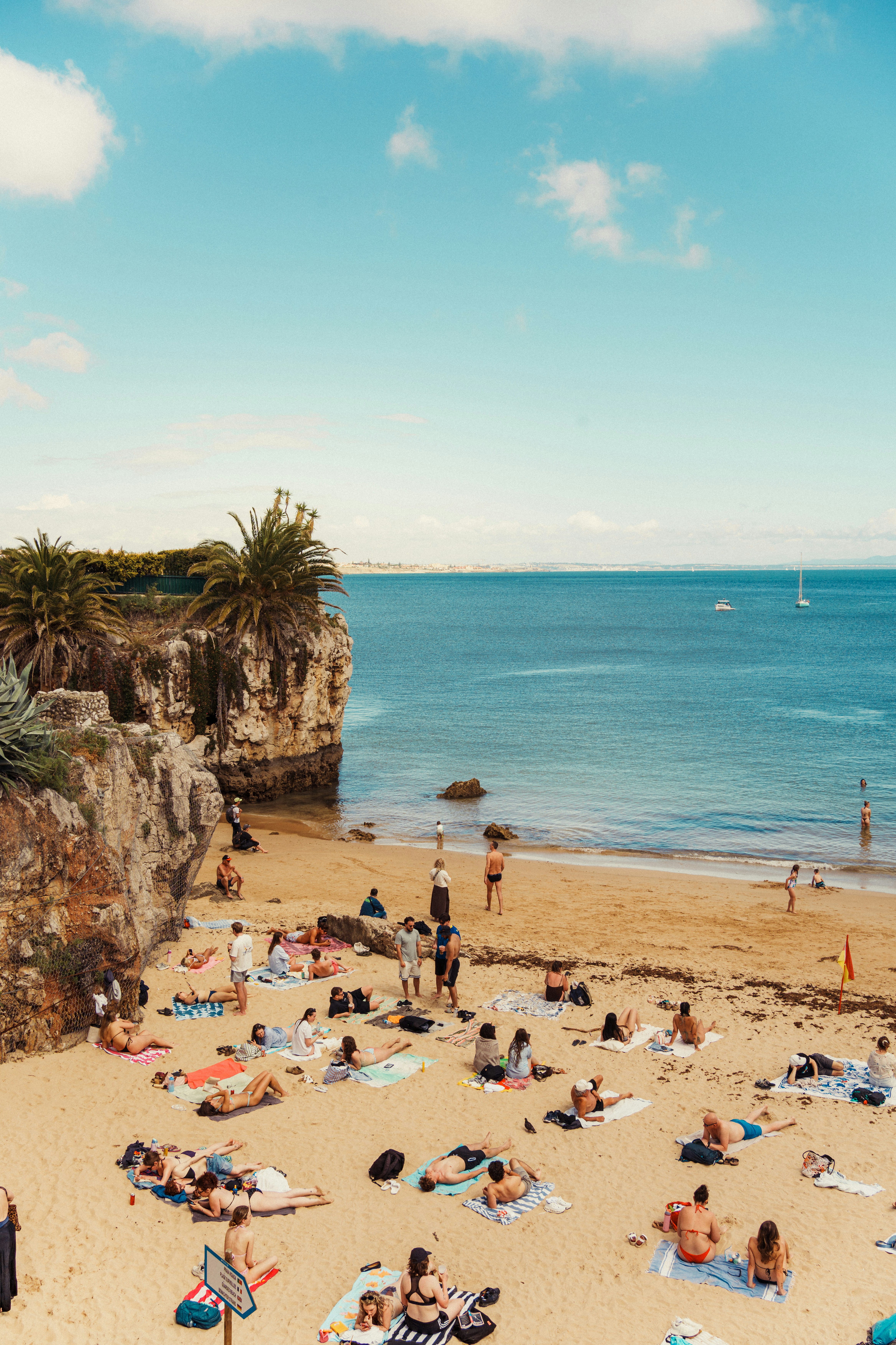 Crowded Beach With People Sunbathing, Cliffs, And Blue Ocean. HD mobile wallpaper