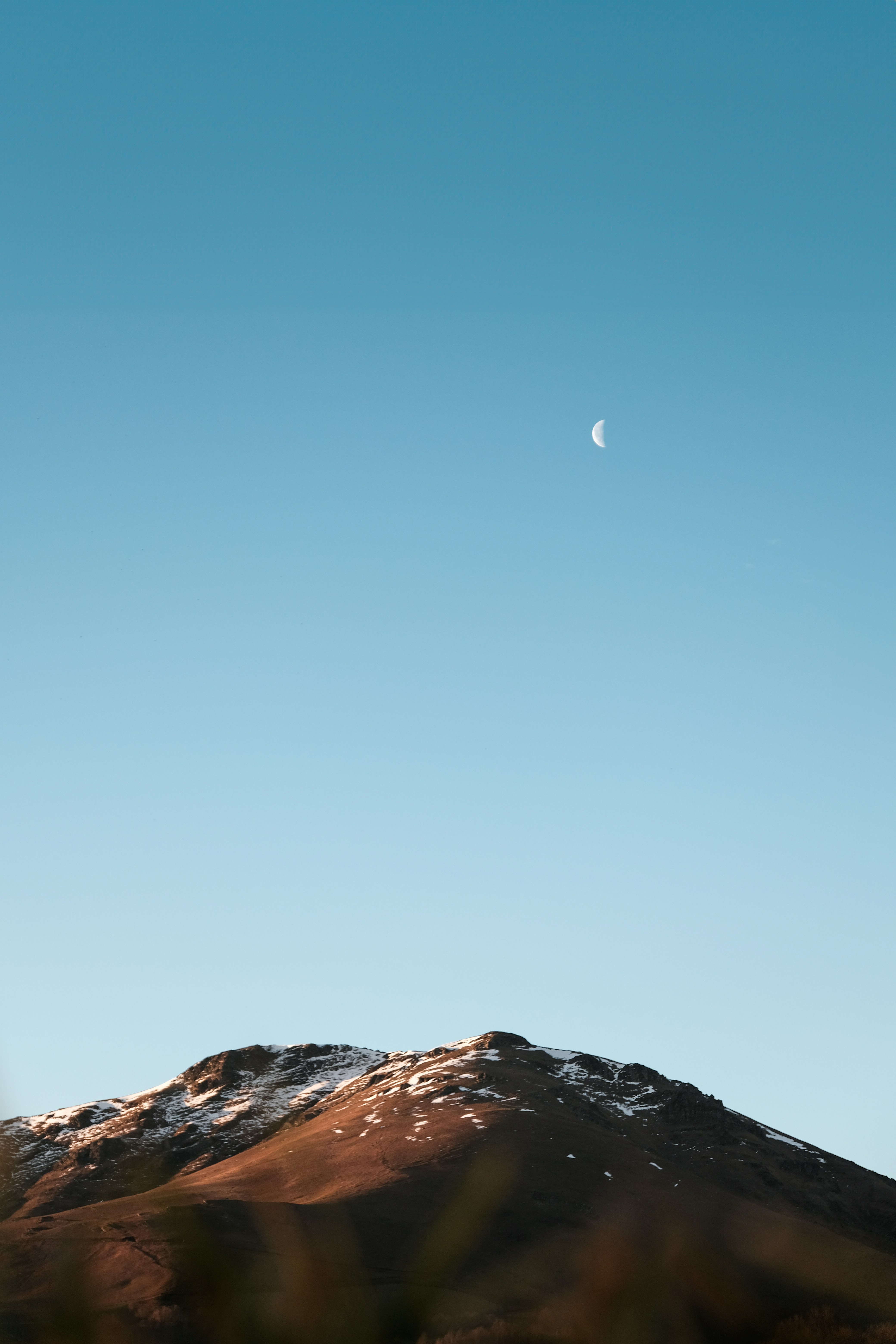 月亮弯在雪山上空的晴蓝天手机壁纸高清图片