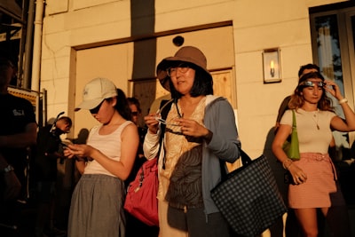 金色时光下的群众身影，手中戴着日食眼镜，站在建筑前方。