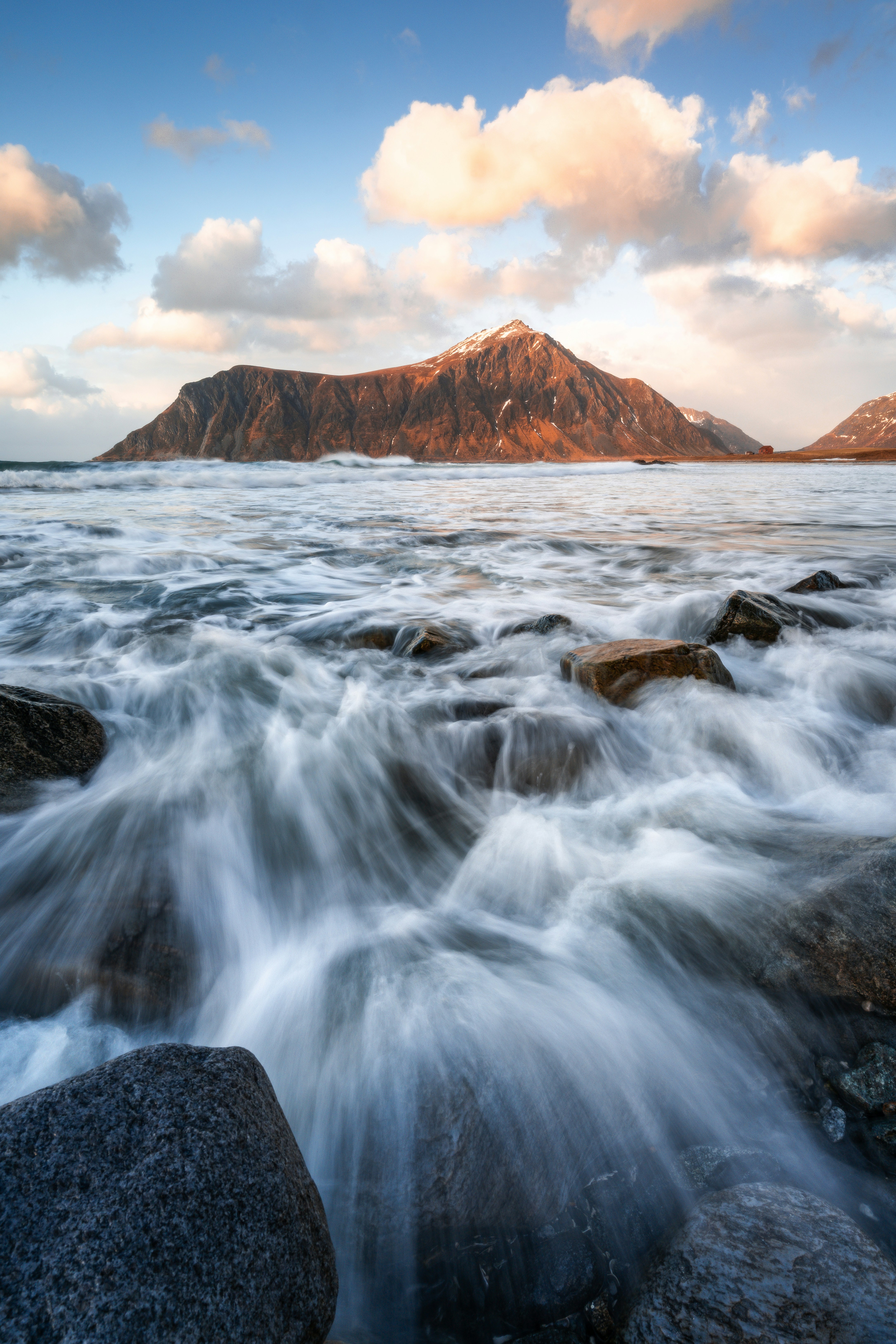 Dynamic Ocean Waves Flow Over Rocks Towards A Large Mountain. HD mobile wallpaper