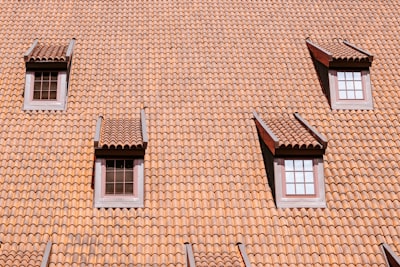 Four Dormer Windows Set Into A Sloping Roof Covered In Orange Clay Tiles wallpaper preview