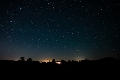 A Beautiful Perseid Meteor Streaks Across A Clear, Starry Night Sky Above A Silhouetted Countryside Landscape In France. wallpaper preview