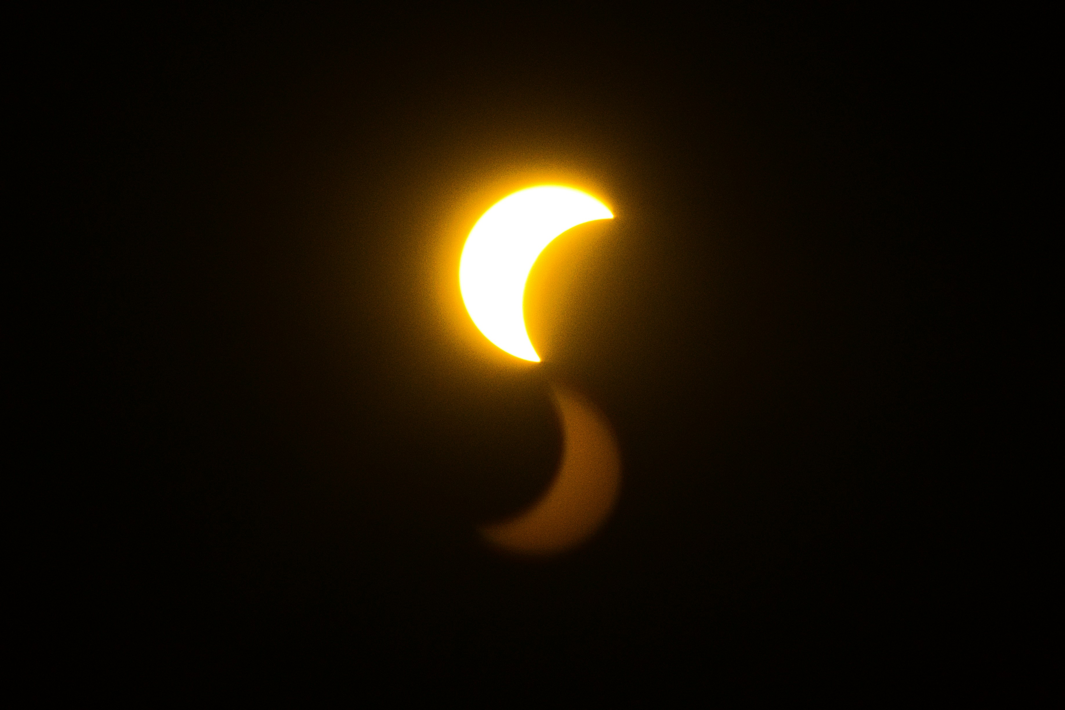 A Bright Crescent Sun With A Faint Reflection Against A Black Sky. HD mobile wallpaper