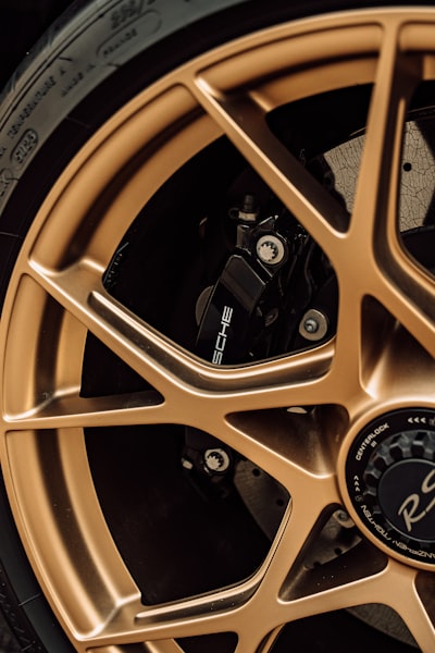 A Gold Alloy Wheel With A Black Brake Caliper On A Sports Car. wallpaper preview
