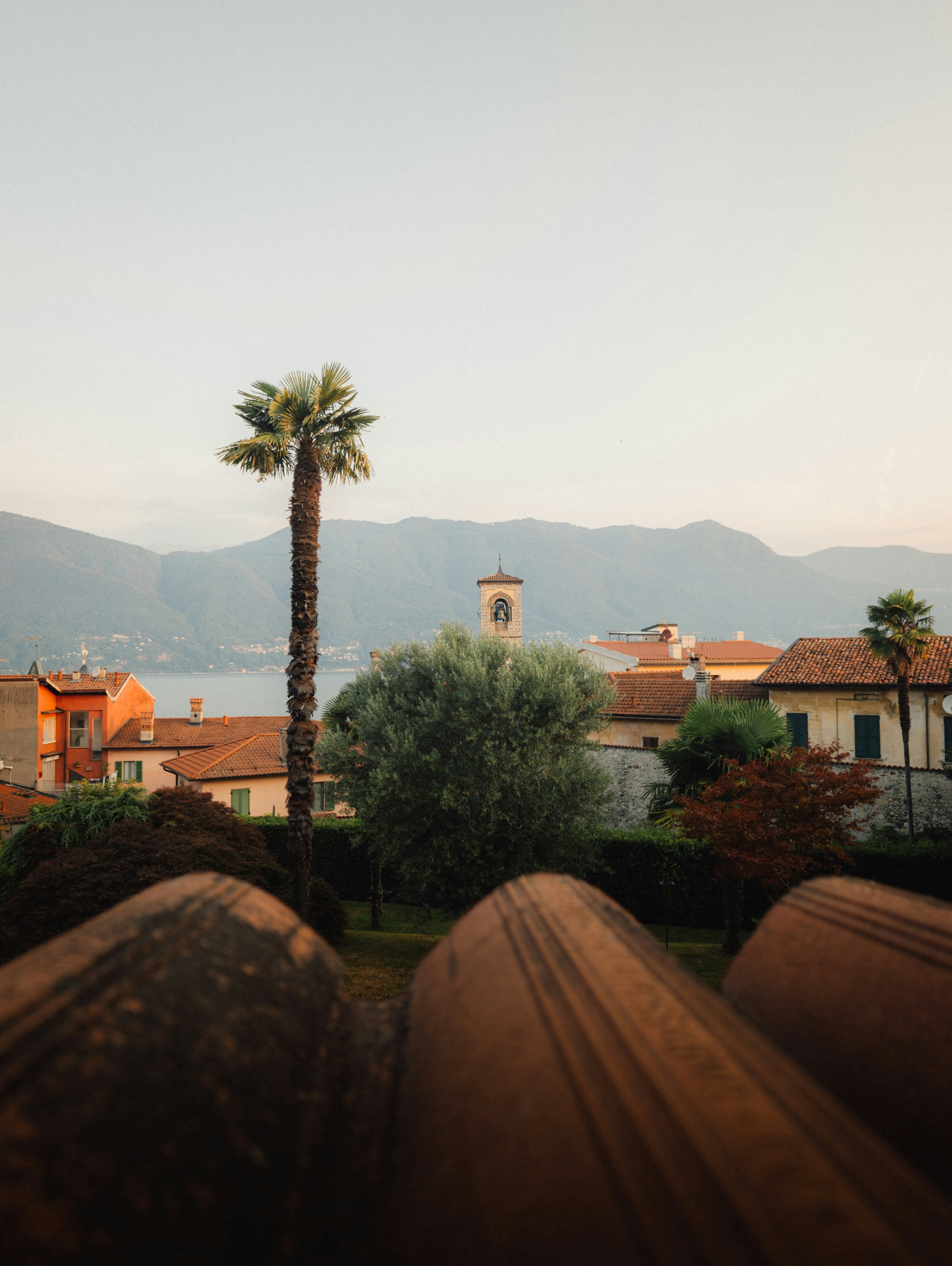 Terracotta Roofs Overlook A Village, Lake, And Distant Mountains. HD mobile wallpaper