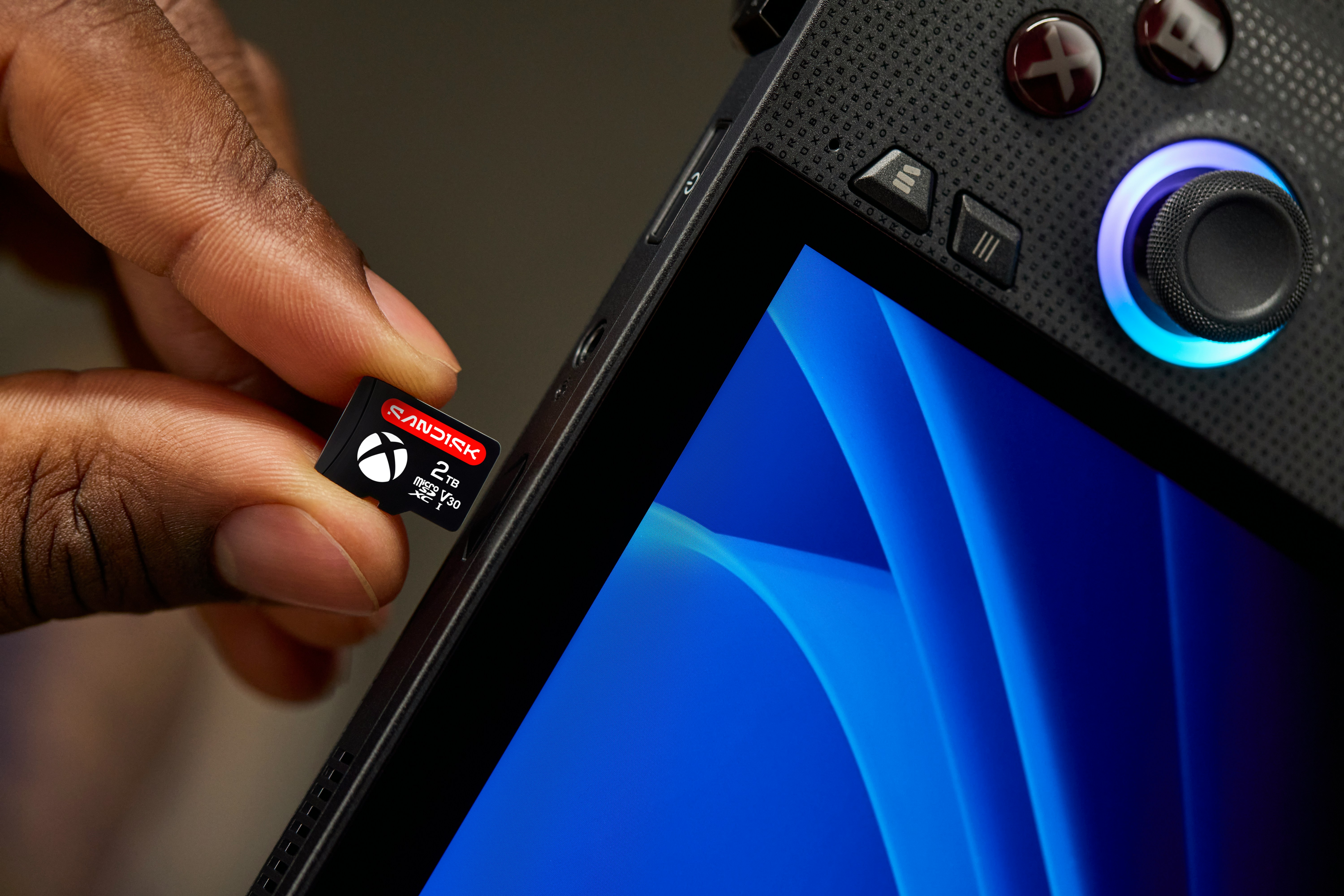 Hand Inserting Xbox Memory Card Into Portable Gaming Device. HD mobile wallpaper