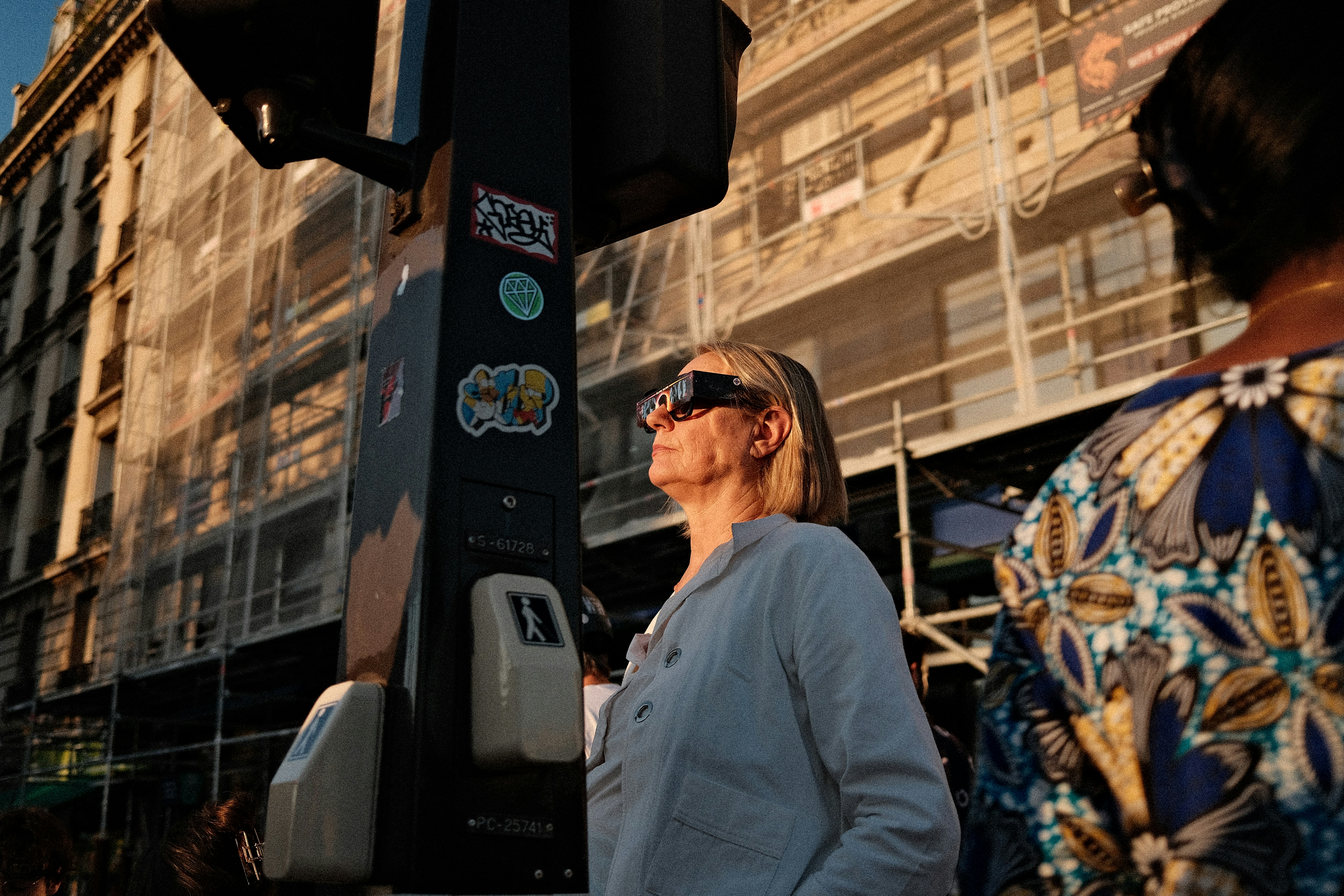 A Woman Wearing Eclipse Glasses On A City Street During The Golden Hour. HD mobile wallpaper
