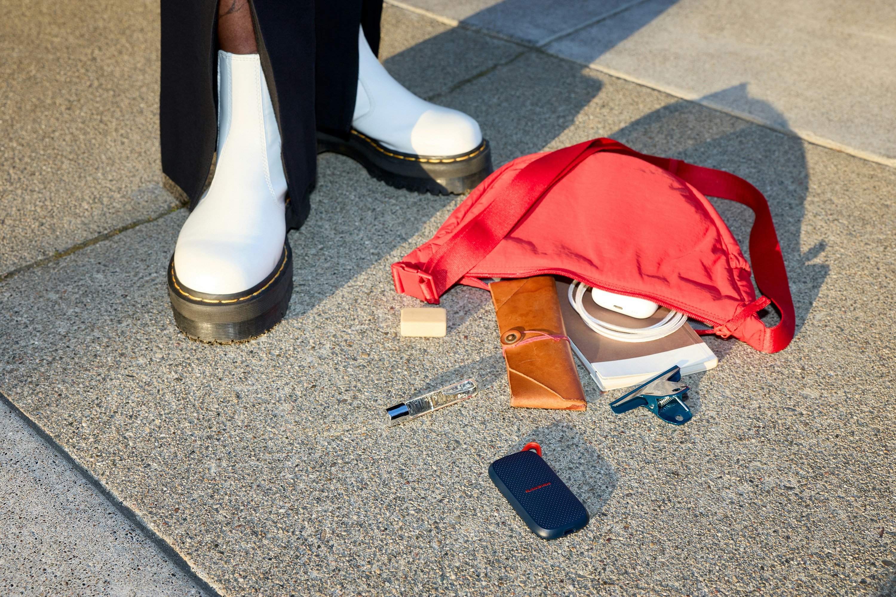 Spilled Red Bag Contents Next To White Boots On Concrete. HD mobile wallpaper