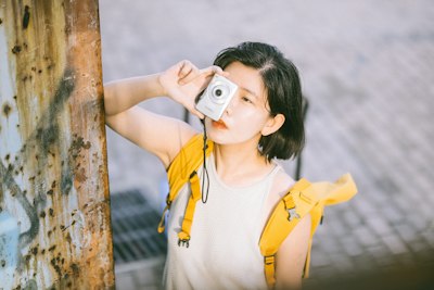 背黄背包的女子执银相机凝视壁纸预览