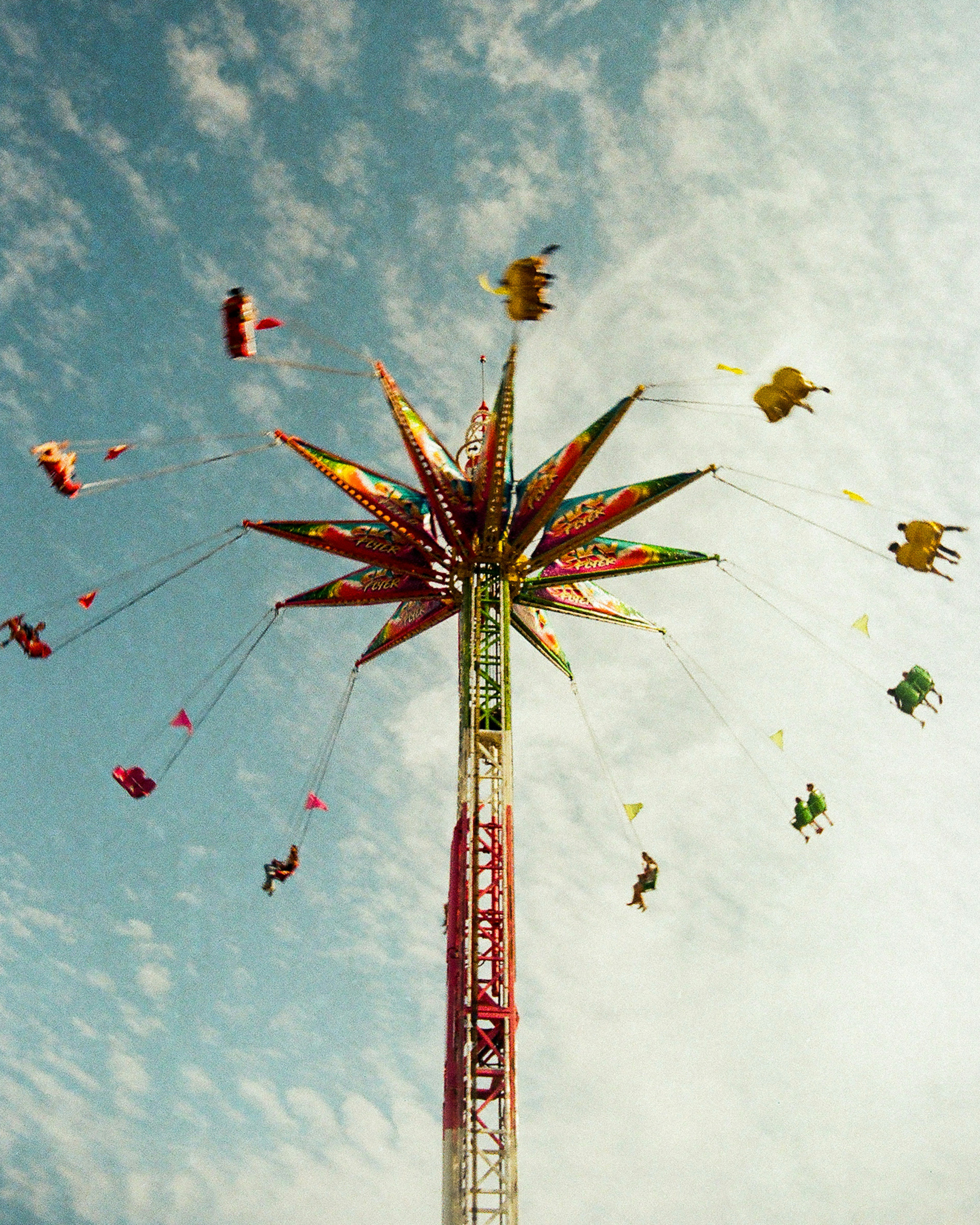 A Tall Swing Ride Spinning People In The Air Against A Cloudy Sky HD mobile wallpaper