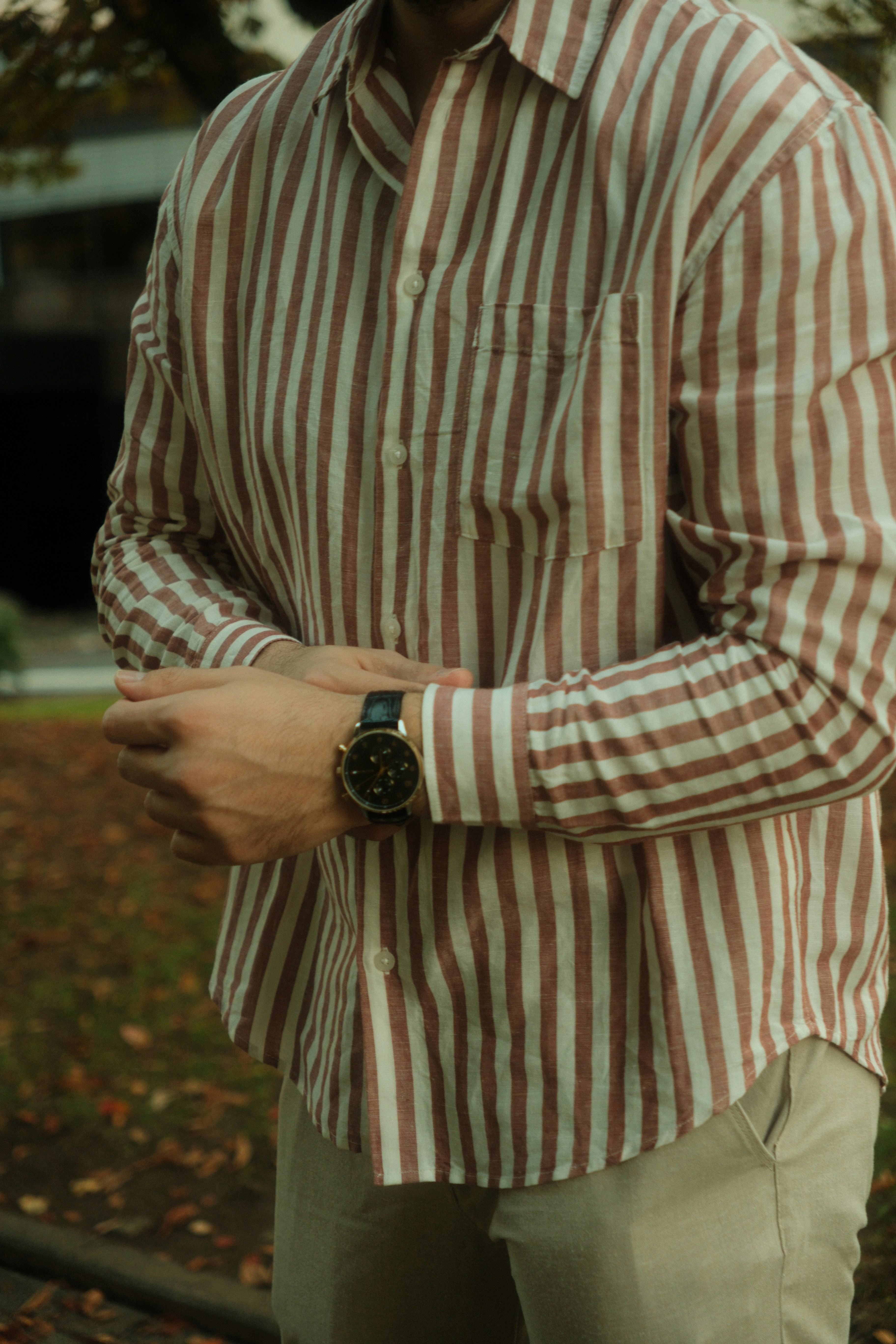 A Person In A Brown And White Striped Shirt Wearing A Black Wristwatch Outdoors HD mobile wallpaper