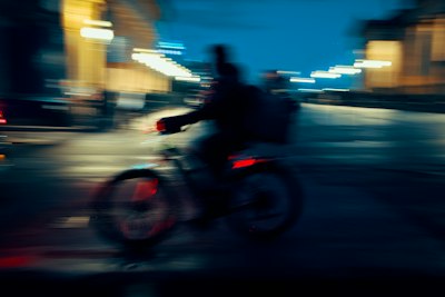A Person Cycling On A City Street At Night With Motion Blur wallpaper preview