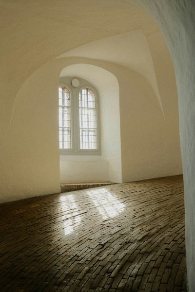 Sunlight Through An Arched Window Onto A Rustic Brick Floor In A Room wallpaper preview
