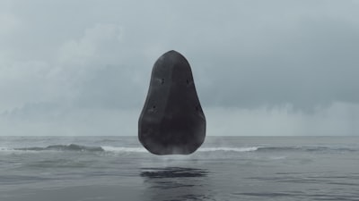 暗色神秘巨石悬于波涛之上阴云天际幻影氛围壁纸预览