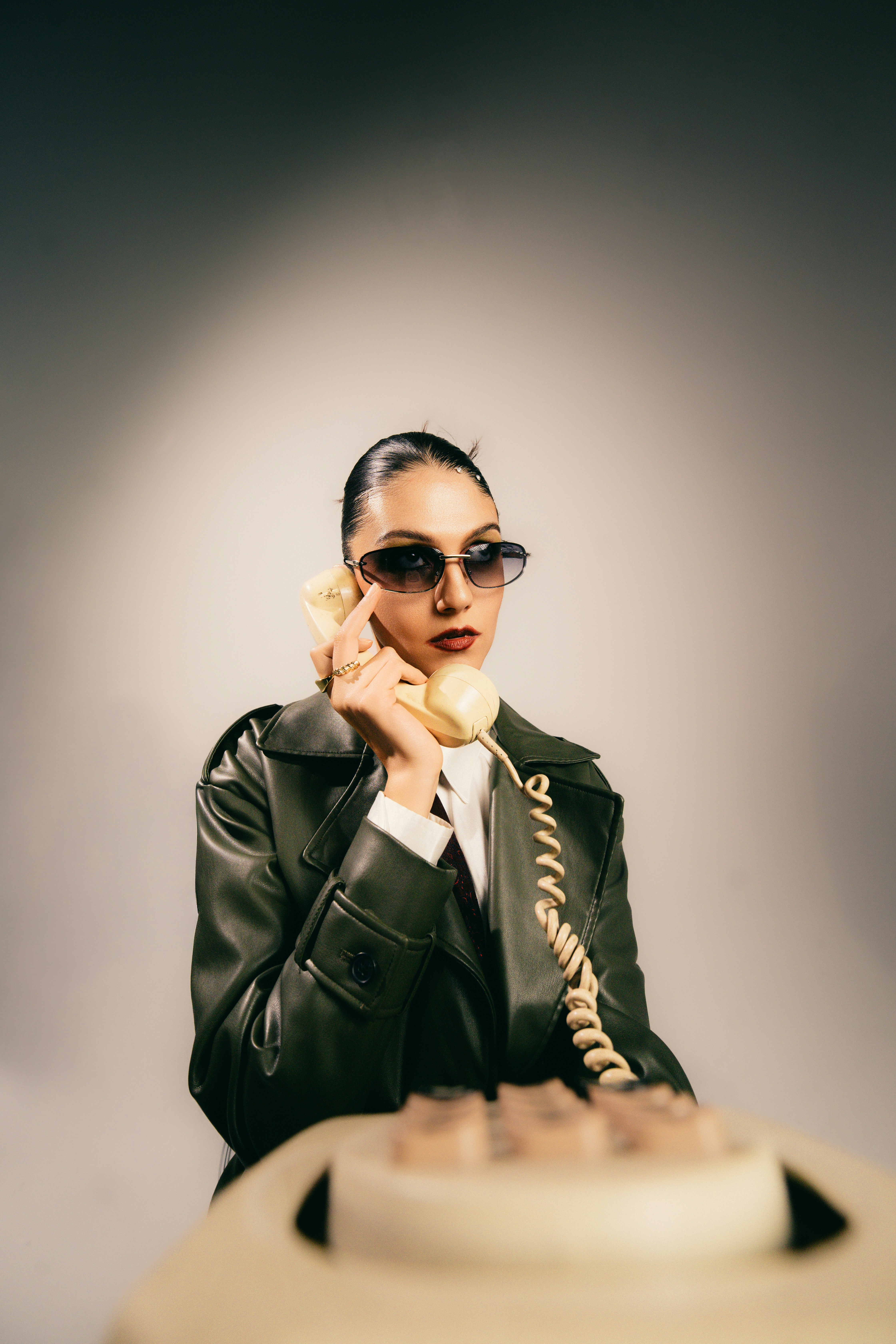 A Woman In A Dark Green Leather Coat And Sunglasses Holding A Vintage Telephone Receiver HD mobile wallpaper