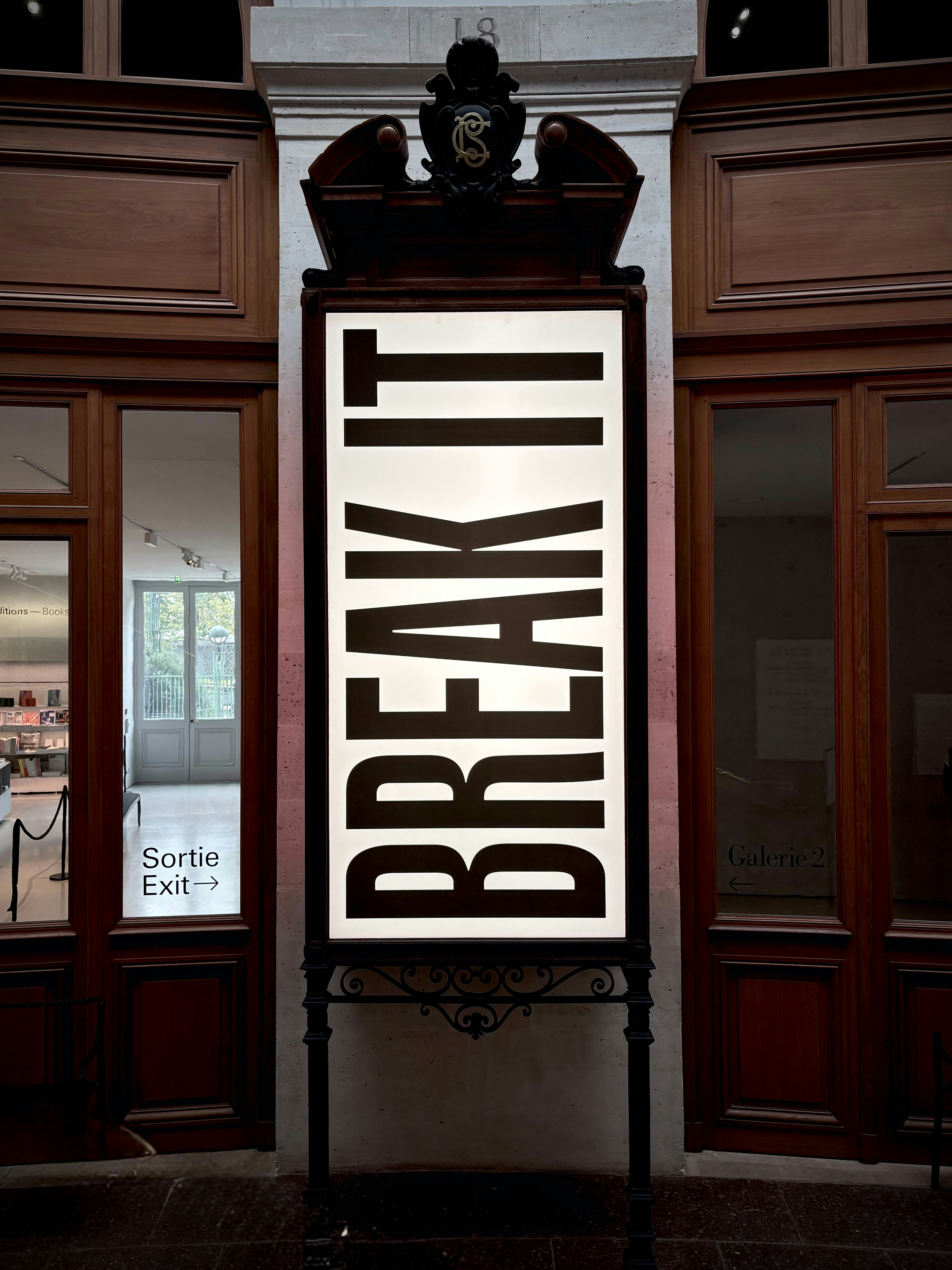 A Vertical Illuminated Sign Reading BREAK IT In Black Letters Between Two Wooden Doors HD mobile wallpaper