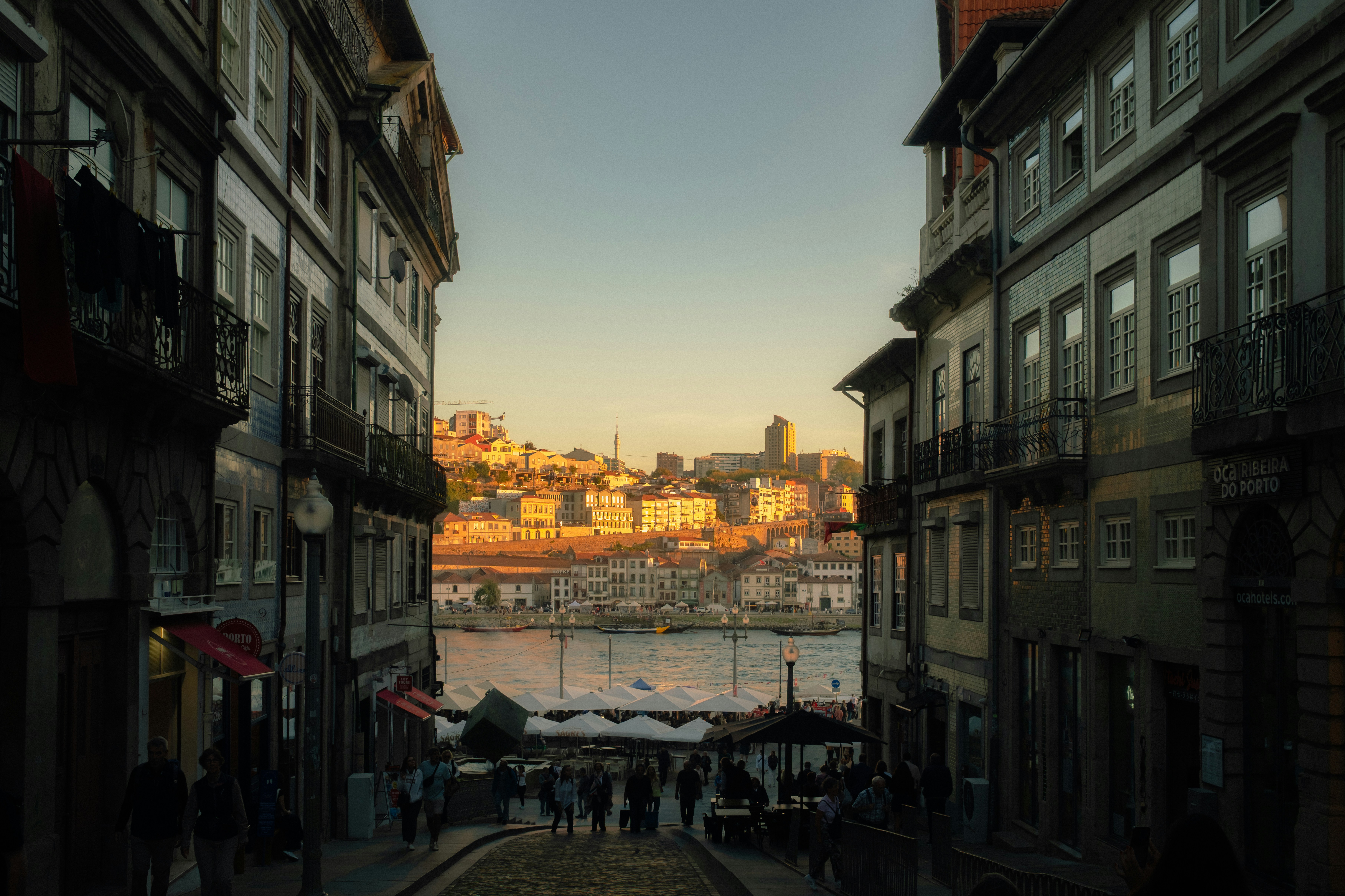 A Narrow Street Leading To The Douro River In Porto With Historic Buildings And Golden Light HD mobile wallpaper