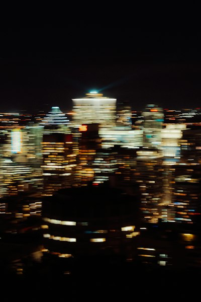 A Blurred Night View Of Illuminated Skyscrapers In A City Skyline wallpaper preview