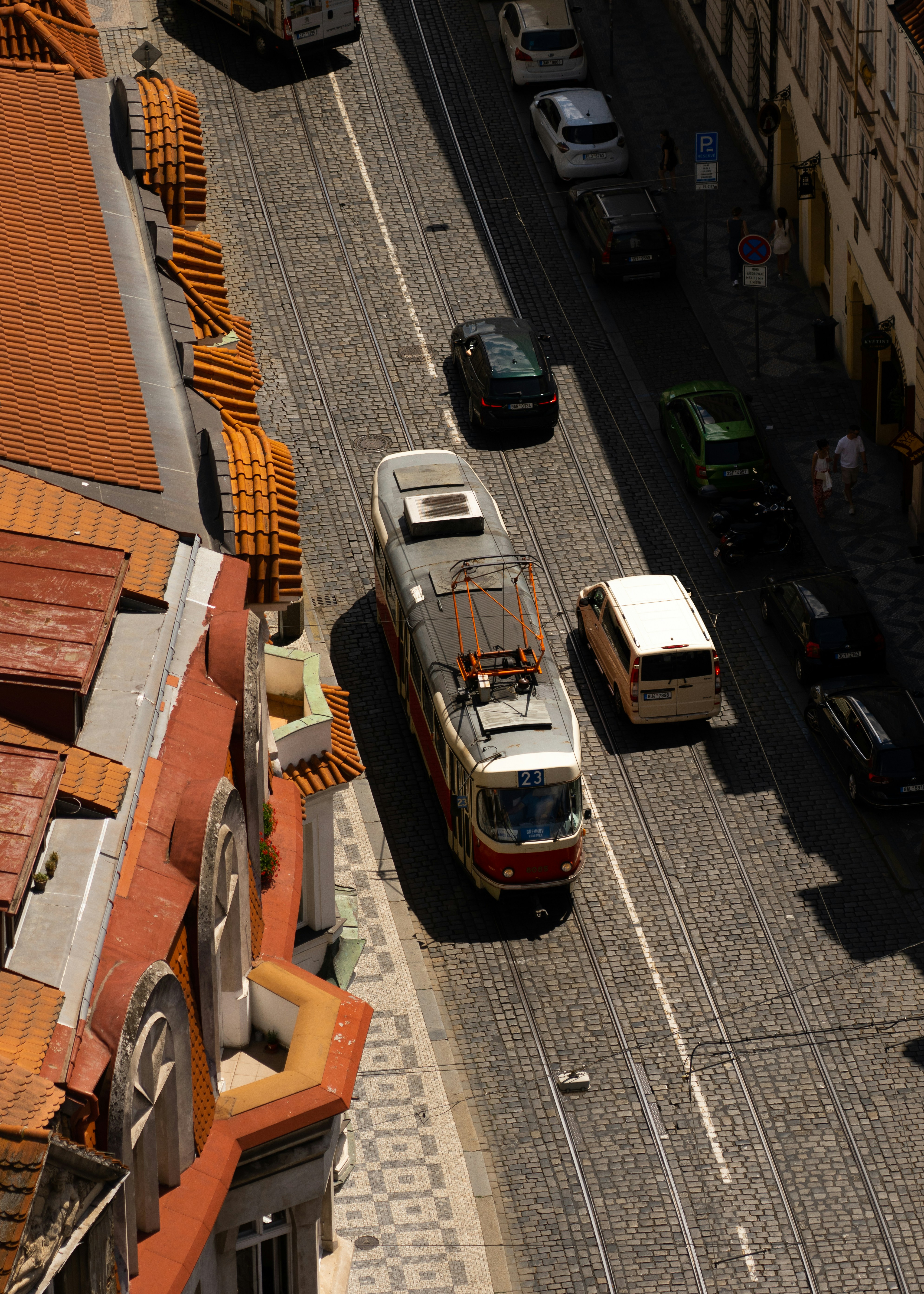 A Tram Travels Down A Cobblestone Street With Cars HD mobile wallpaper