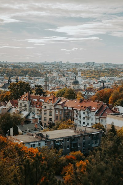 An Aerial View Of Lviv With Historic Buildings And Autumn Trees Under A Cloudy Sky wallpaper preview