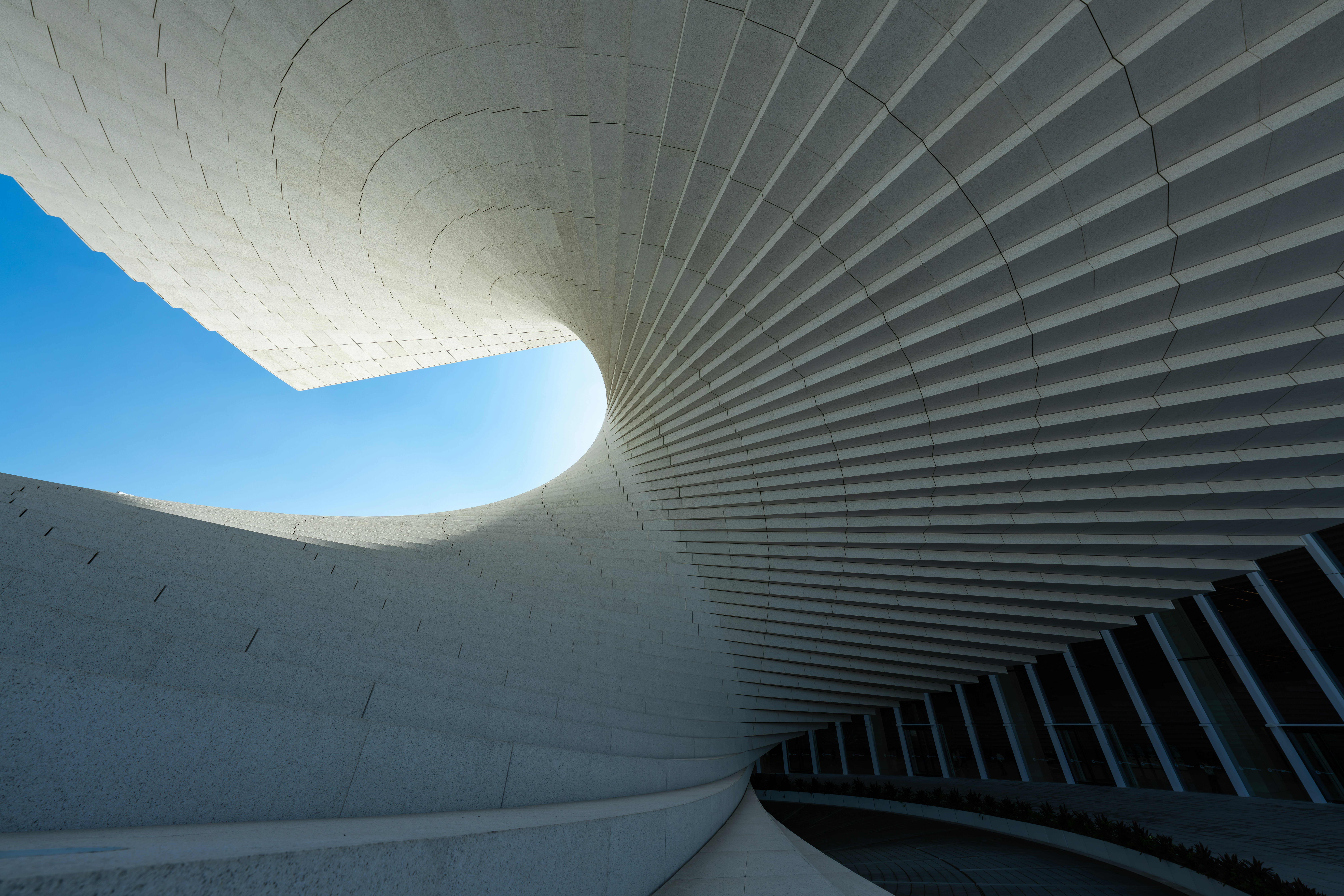 A Curved White Architectural Structure With Repeating Panels Against A Clear Blue Sky HD mobile wallpaper