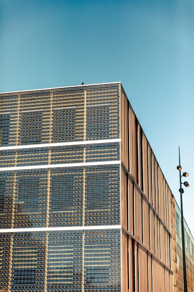 A Tall Building With Lots Of Windows Next To A Street Light wallpaper preview